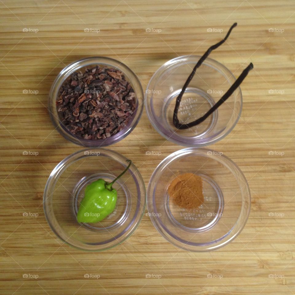 Variety of spices in bowls on wooden cutting board.