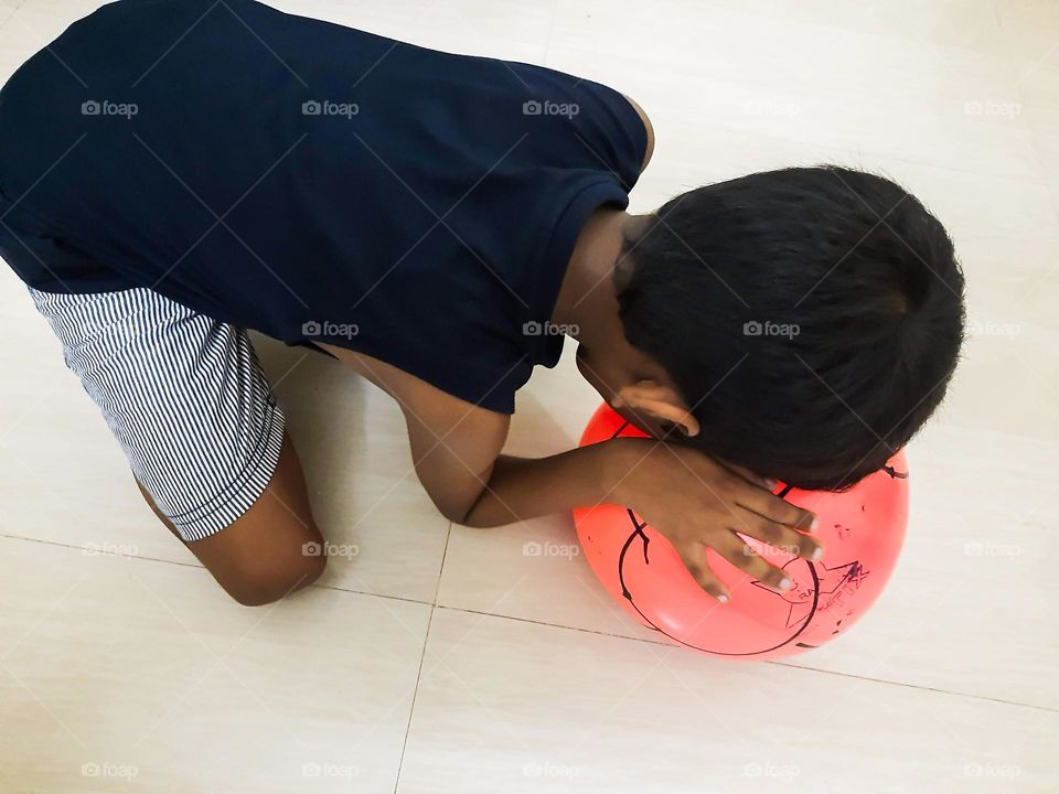 Boy doing exercise at home with his Ball