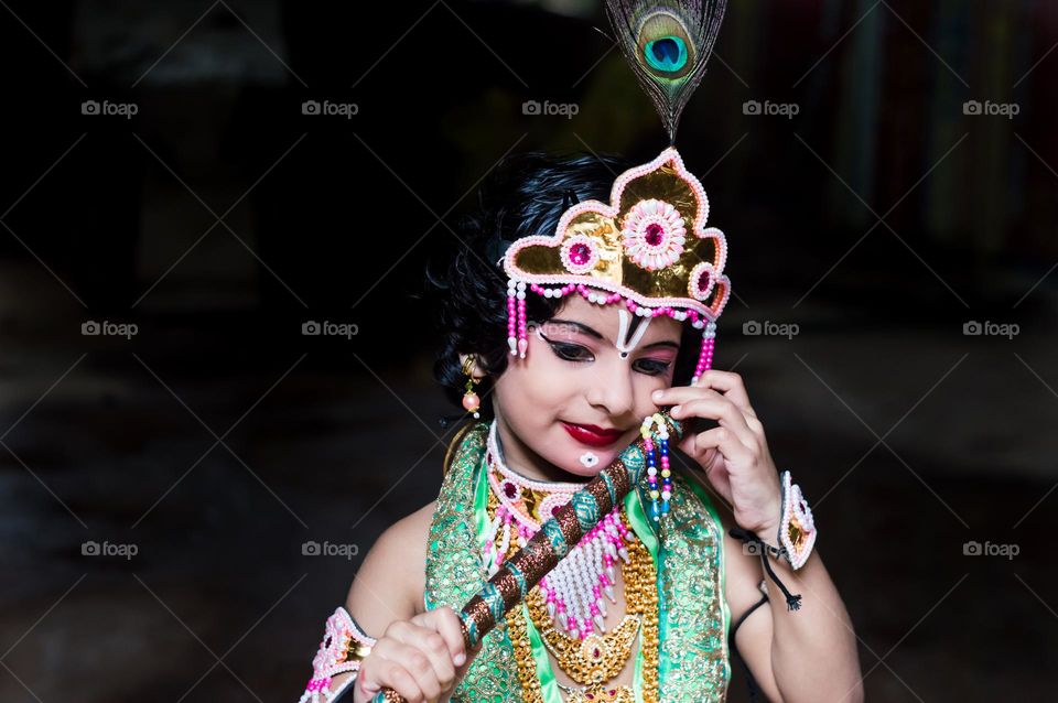 Indian kid wearing God Shri Krishna costume for Shrikrishna Janmashtami festival.