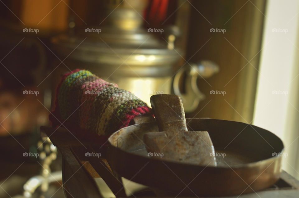 a cozy country dwelling with its own little special charms in the form of old cast-iron pans or homemade knitted potholders. in the background you can see a bronze teapot, are still used in the villages and you will never find among city ​​dwellers