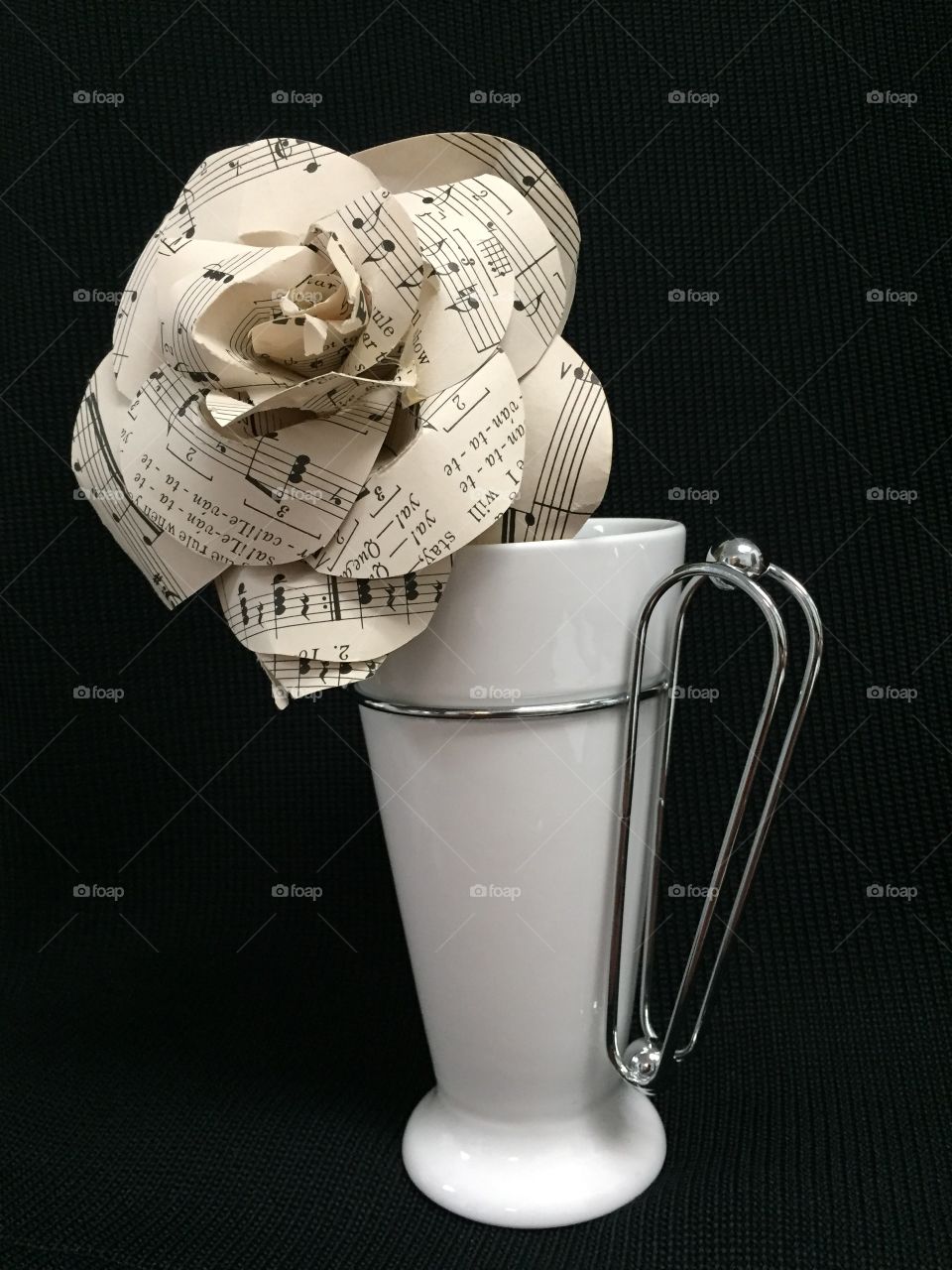 Black and white flower made of sheet music paper nested in a modern porcelain and metal mug