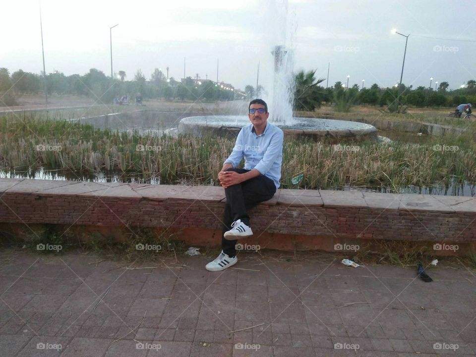 I m sitting against beautiful fountain