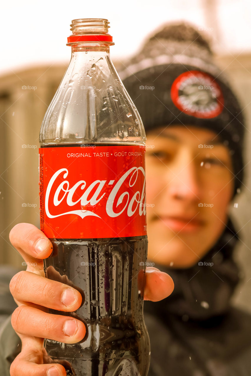 Happy teenager with a bottle of coca cola