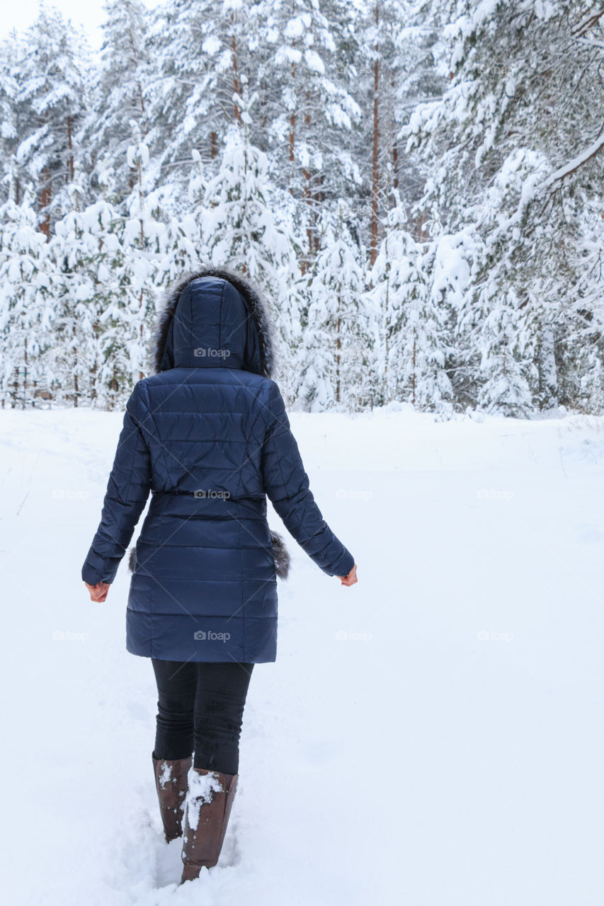 girl goes through a winter forest