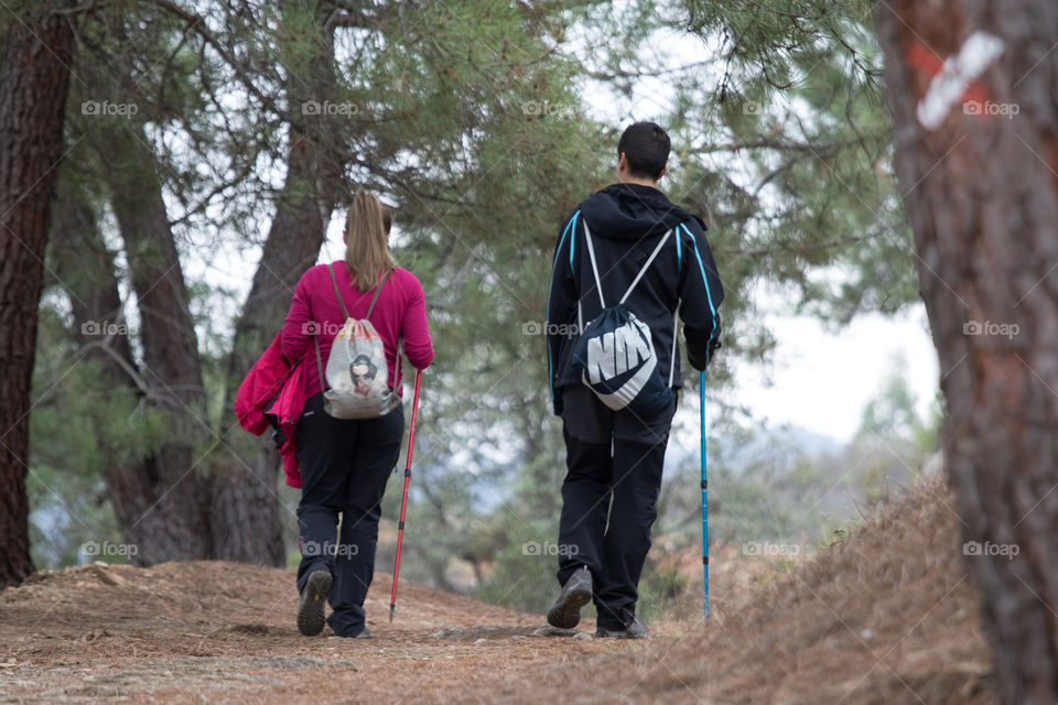 Woman and man walking across forest 