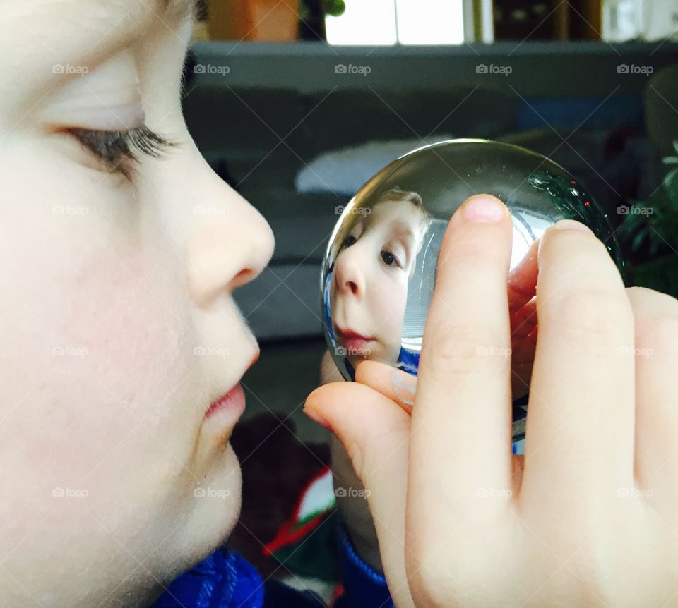 Reflection of boy in shiny silver ball