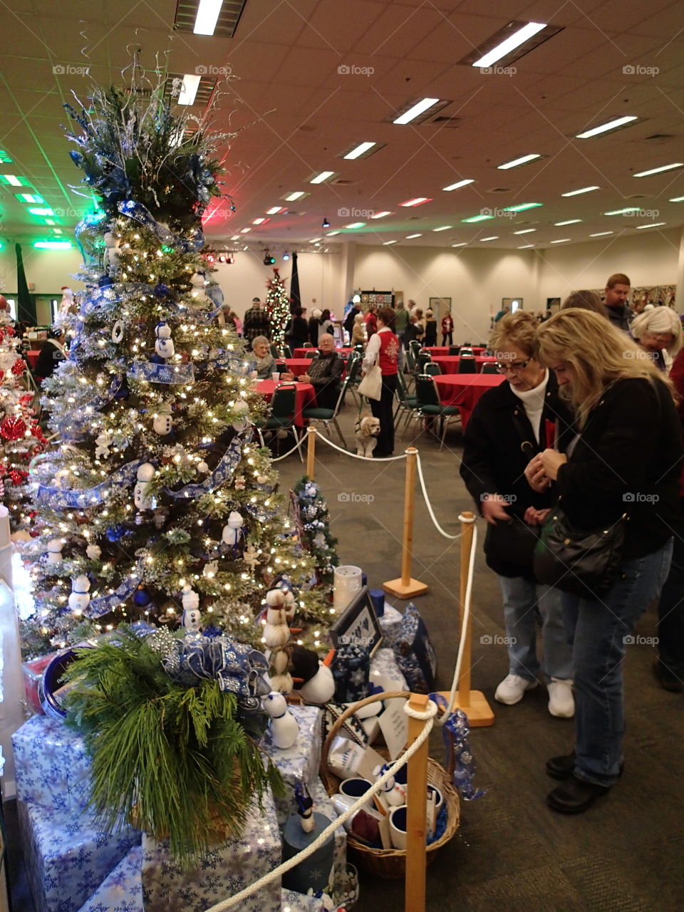 People looking at one of the many beautifully decorated Christmas trees at a fundraising event. 