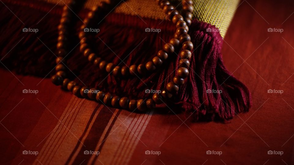 Wooden prayer beads on a red prayer mat