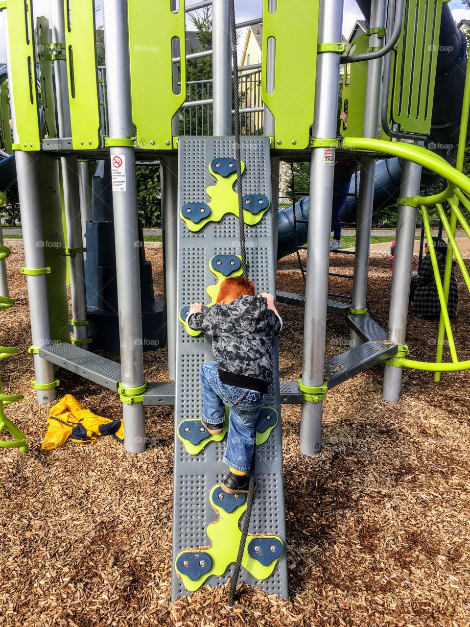 Toddler climbing at the playground. 