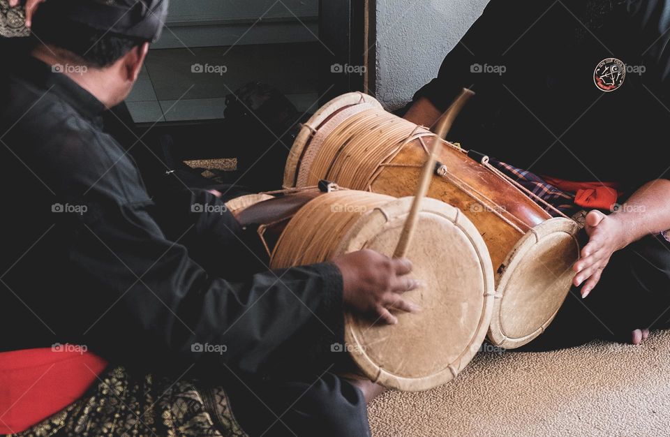 Close-up of a group of local Malay musicians performing traditional portable drums known as Gendang.