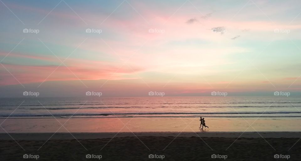Runner on a beach at sunset