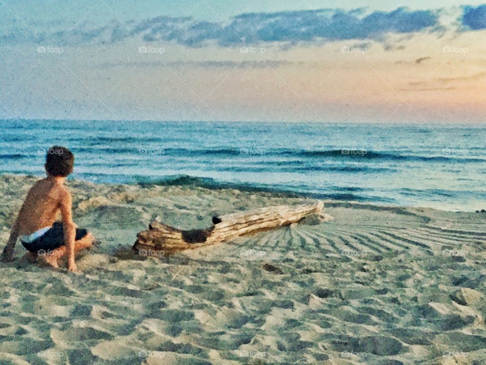 Little boy on sunset beach