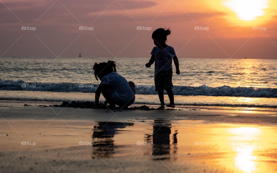 Kids play on the beautiful sunset on the  beach 