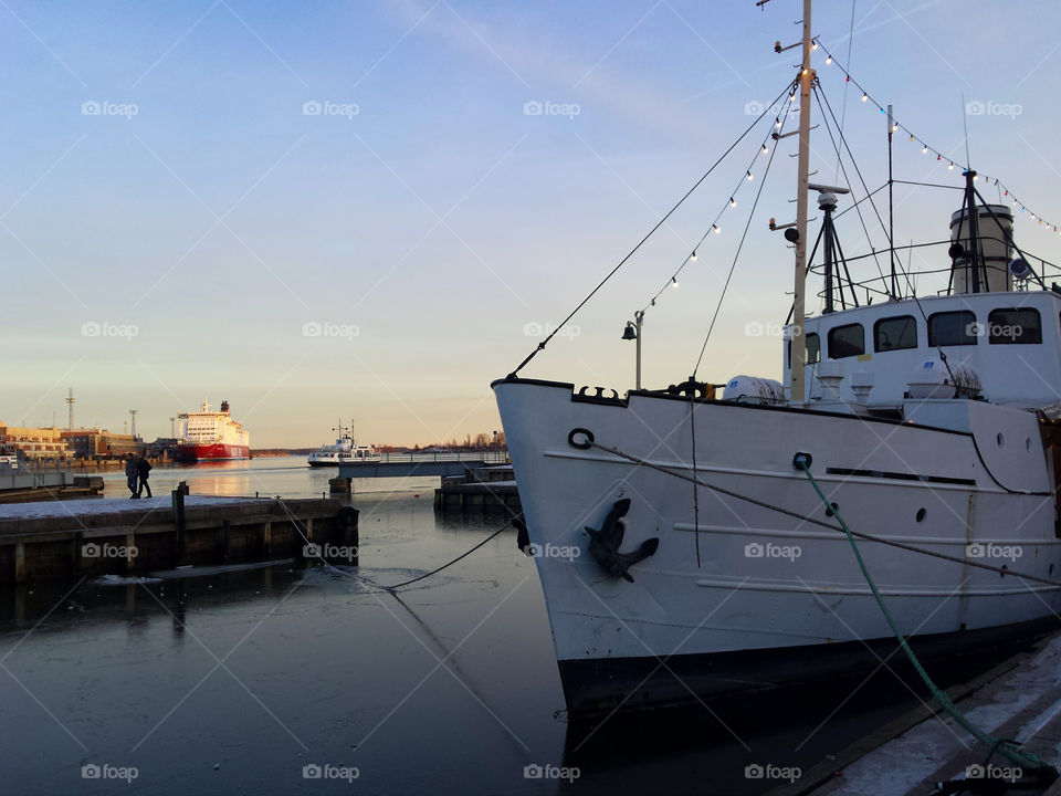 Helsinki harbor on cold evening. Docks and a ship in the market square area of the Helsinki on cold February evening around sunset time