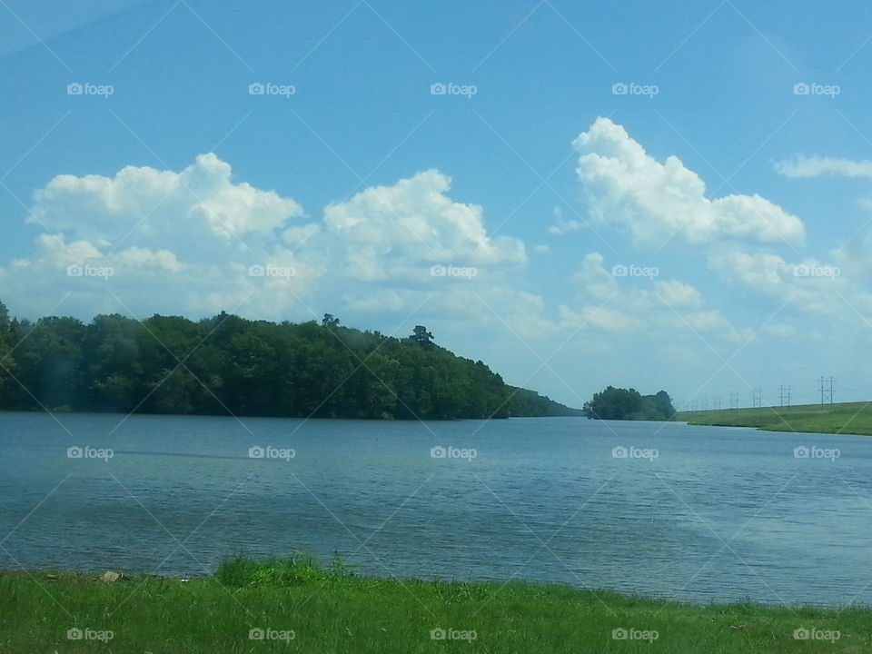 pretty blue sky over water. other side of dam still at the lake
