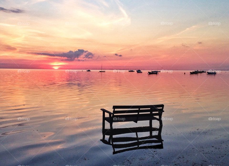 Bench in the water during sunset