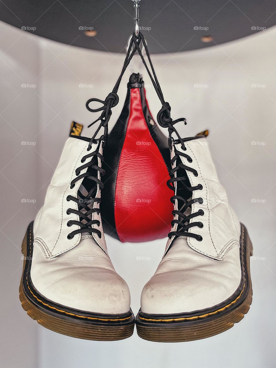 Classic white Doc Marten boots hanging from a speed bag, white boots with speed punching bag, Doc Marten white boots, classic style never goes out of style, boxing and boots, bright white boots
