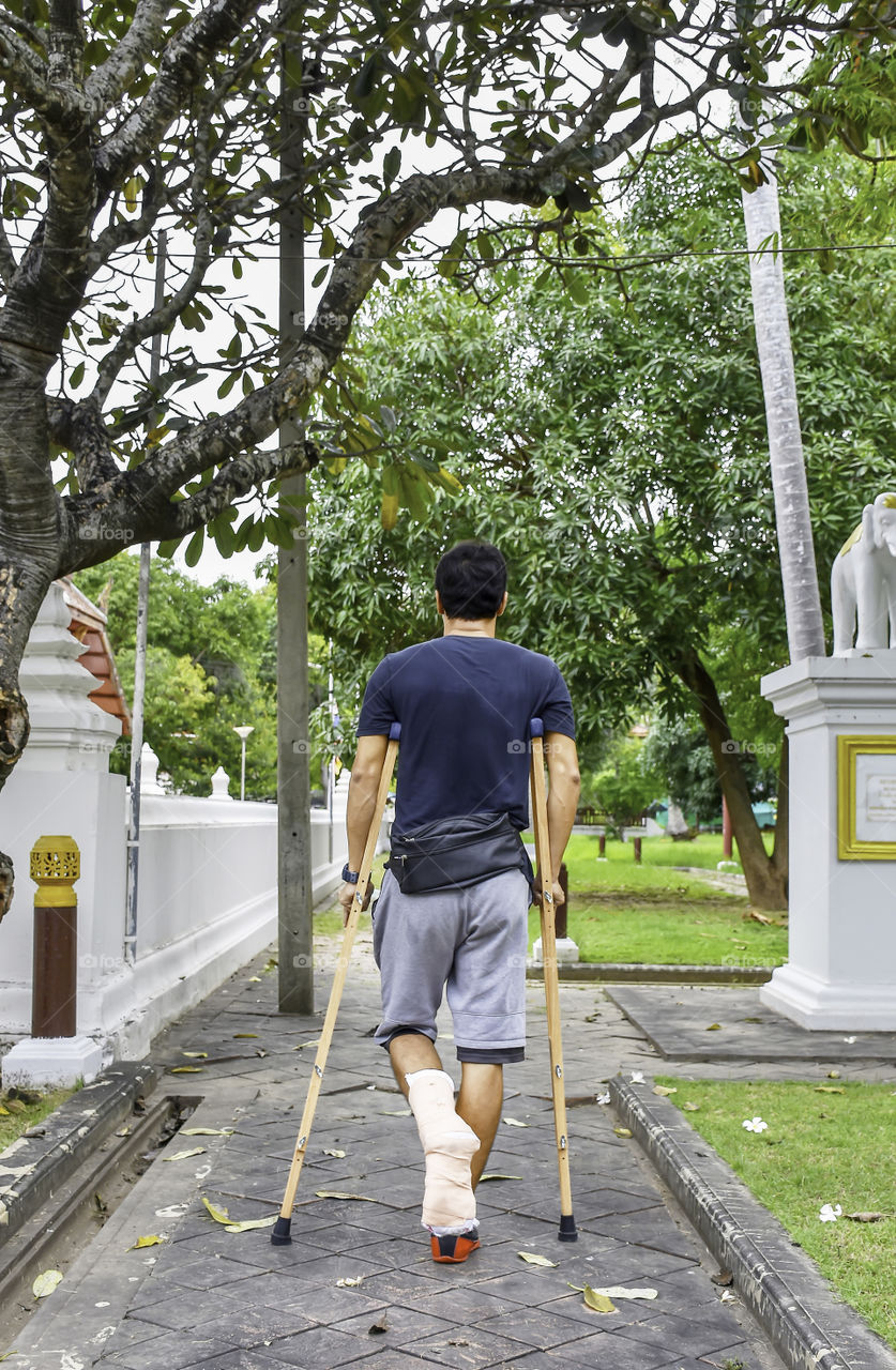 The men used wooden crutches walks in the garden.