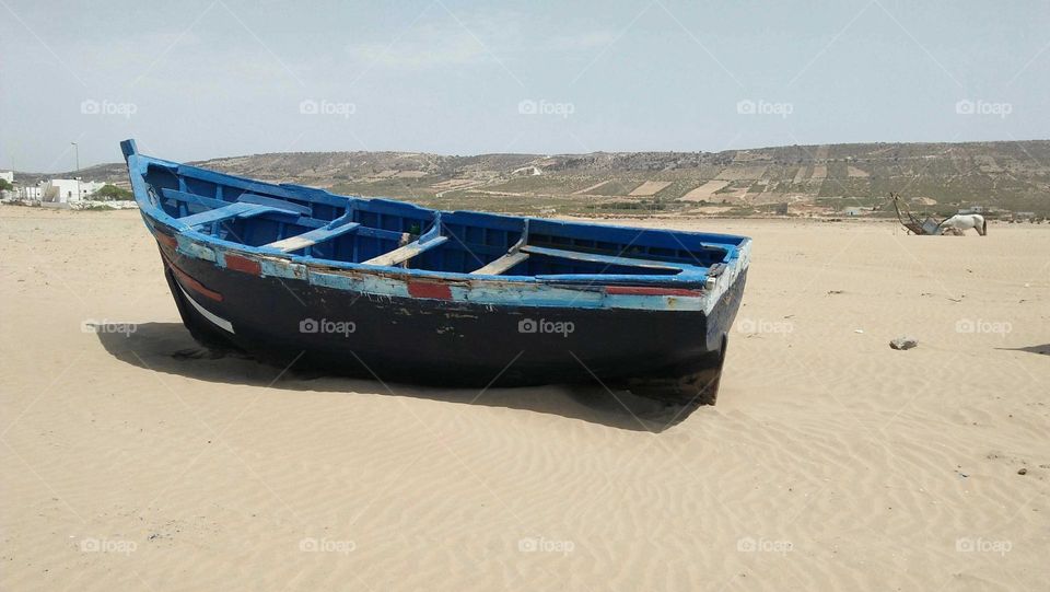 Beautiful blue boat on sand