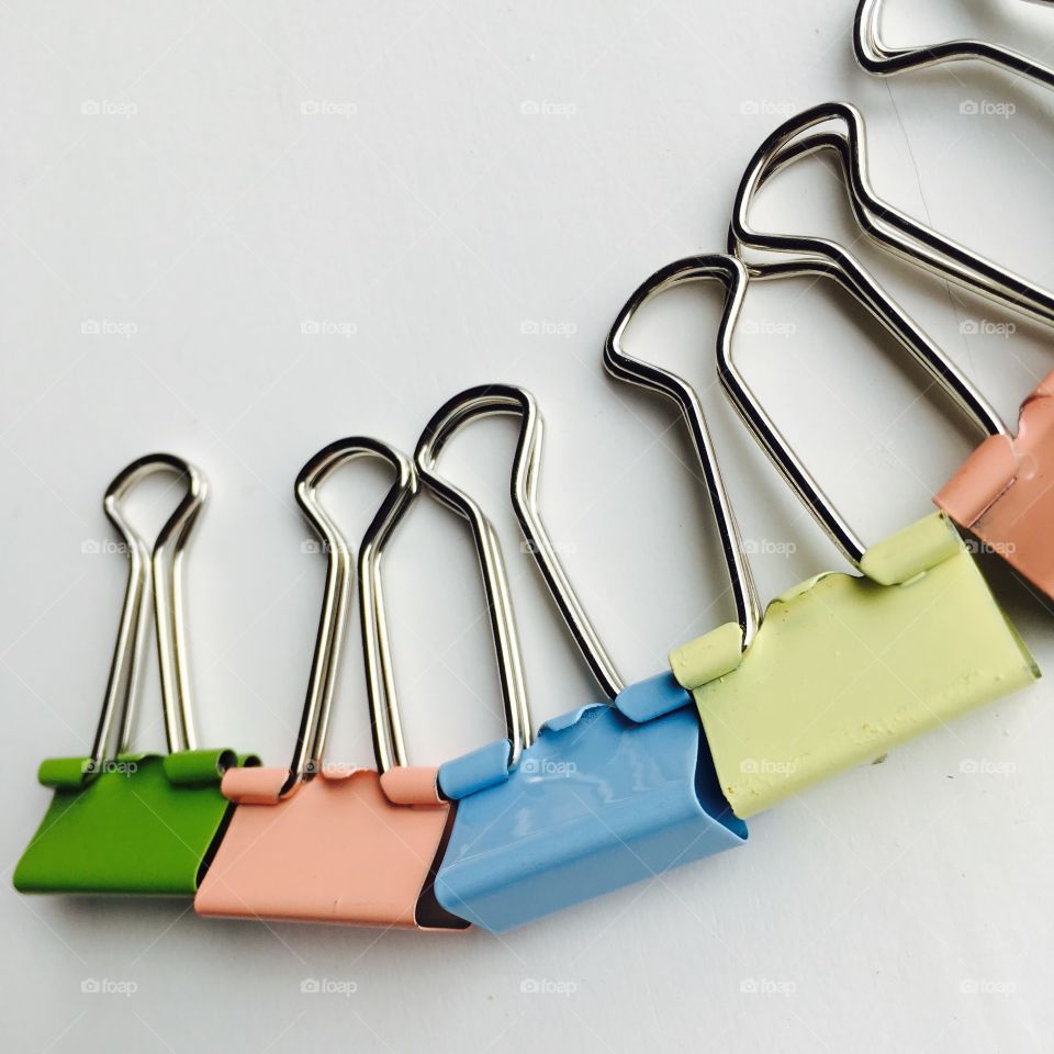 This is random , but very beautiful pastel paper clips on a white background . 