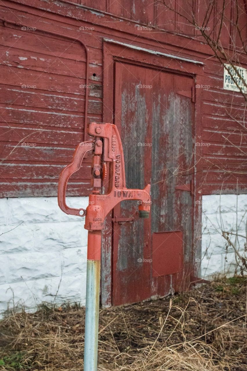 Old water pump by barn.