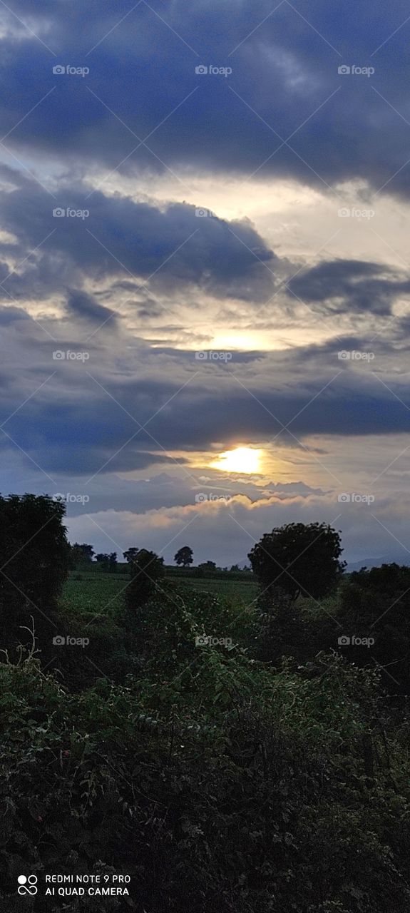 The sun hiding in the clouds looks like someone is blowing fire