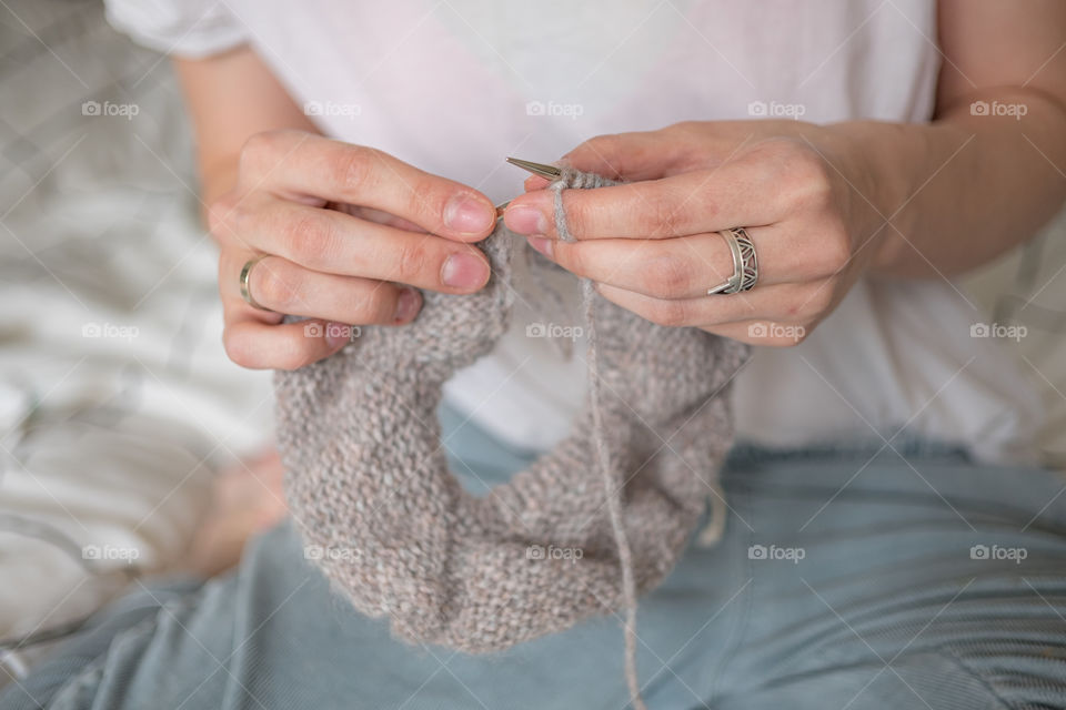 Woman’s hands knitting with needles a sweater 