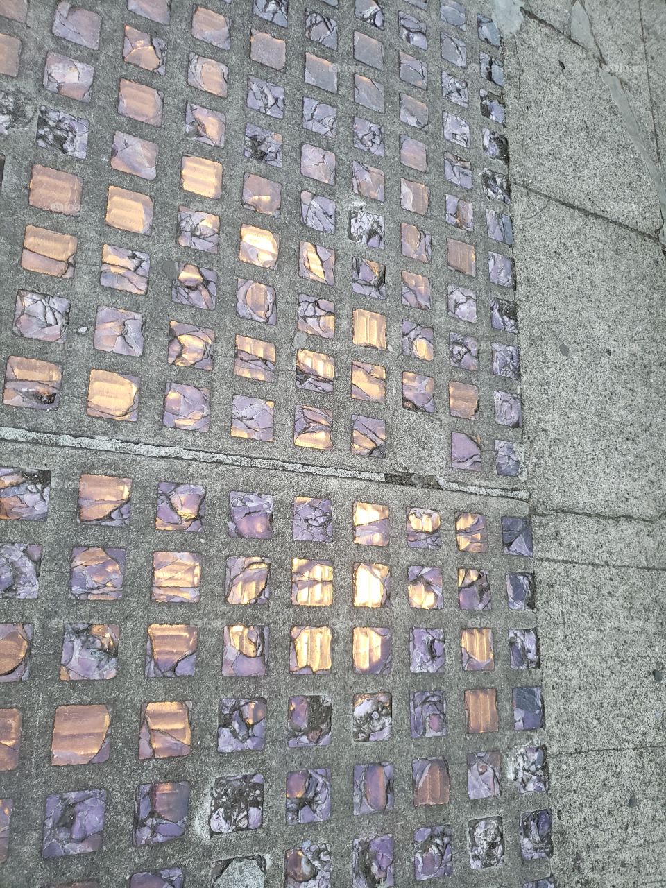 Purple glass in sidewalk with light underneath