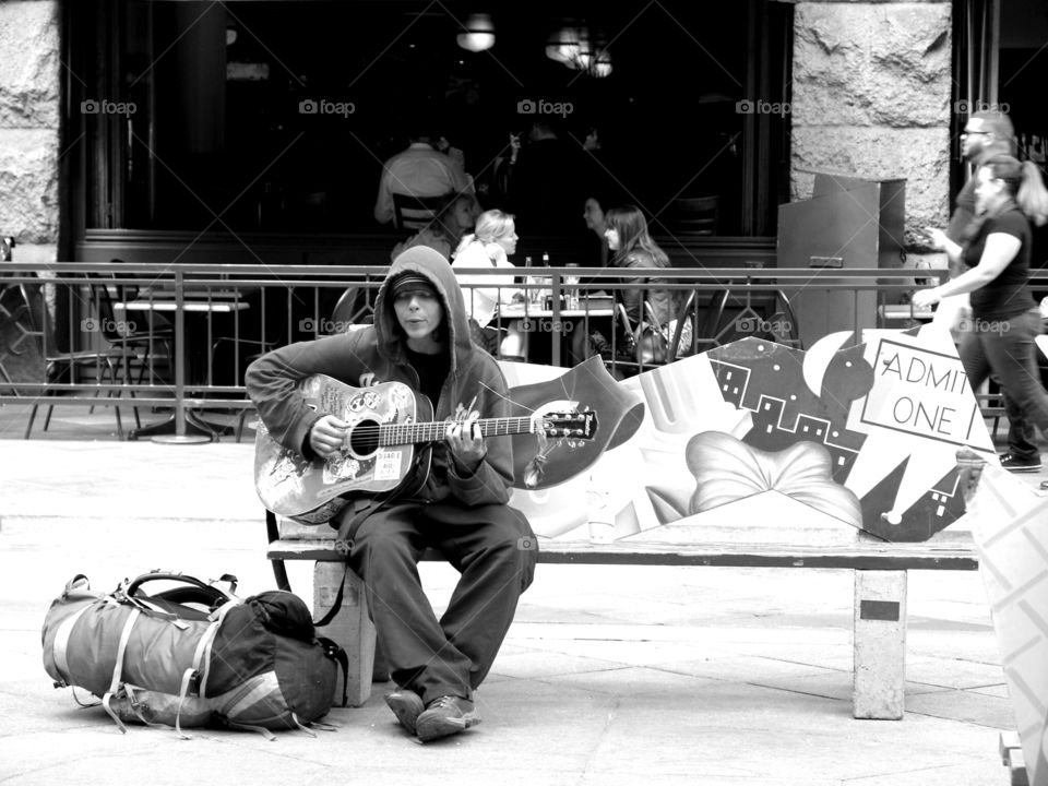 Singing Sorrow. Musician in the street playing his guitar.