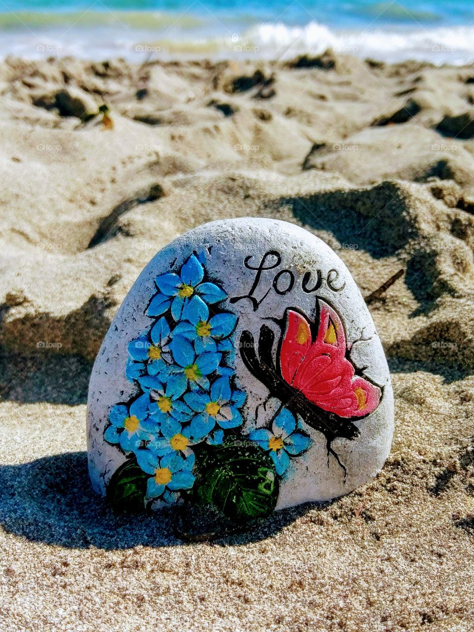Love text on stone at beach