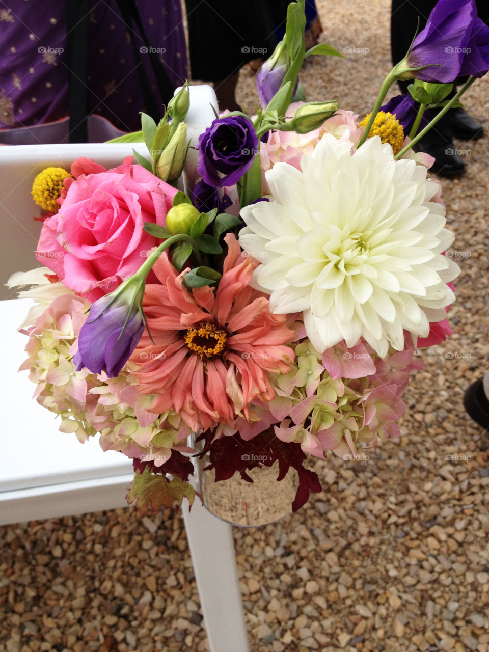 Bouquet of flowers decorating an event chair at an outdoor wedding
