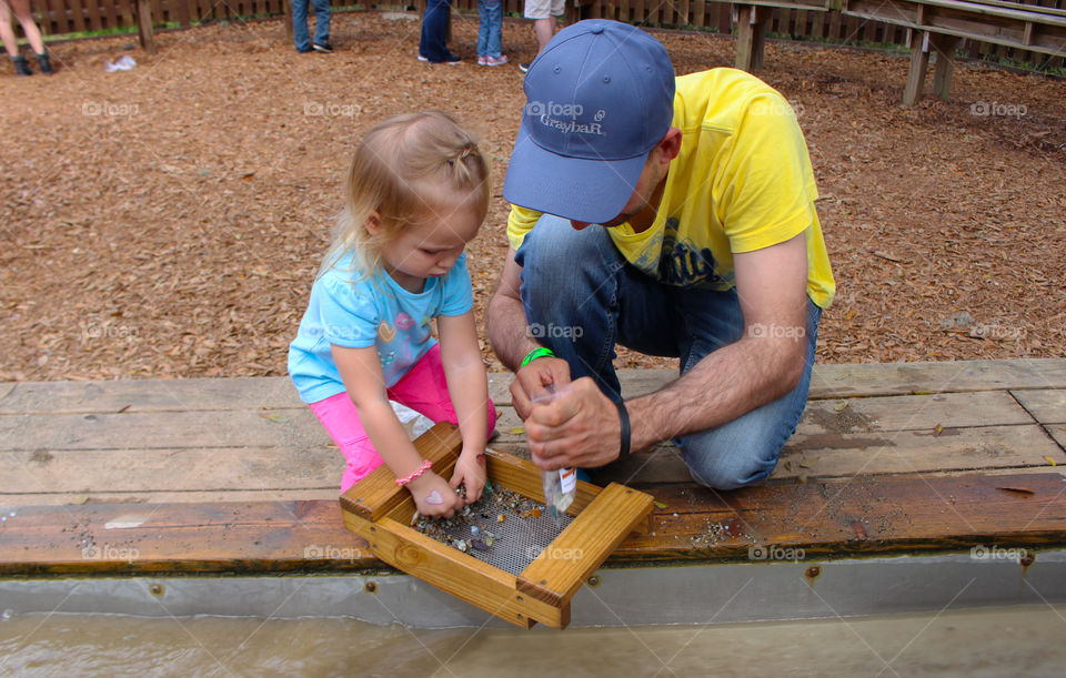 Girl with her father collecting stone