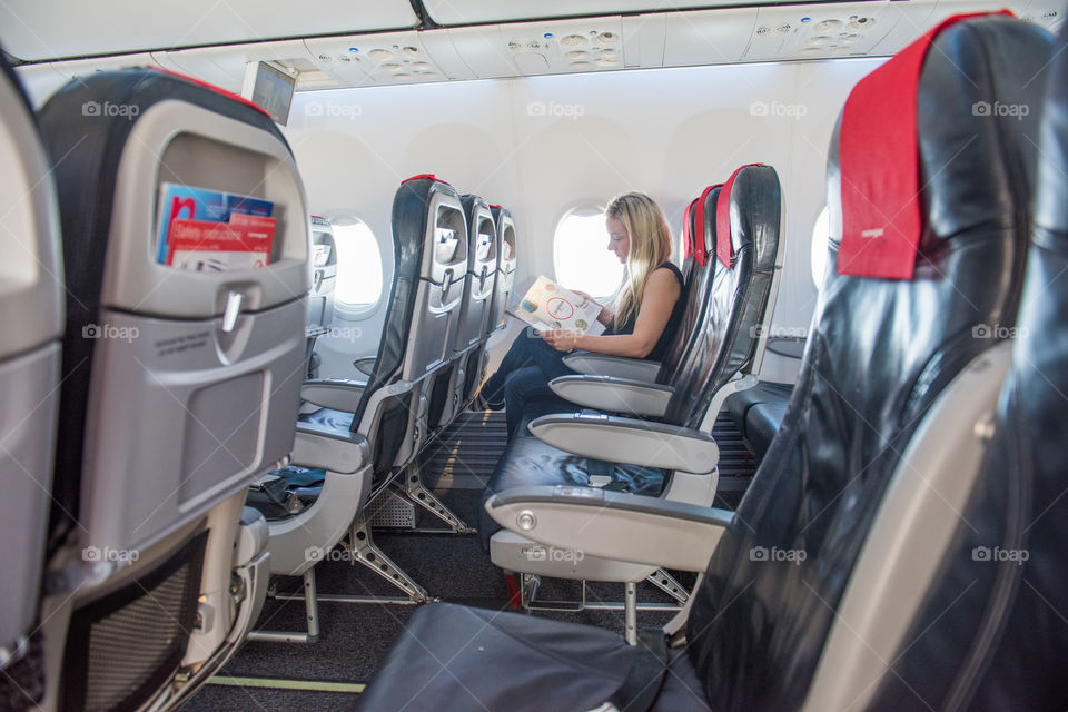 Woman reading the Tax Free catalog on a airplane.