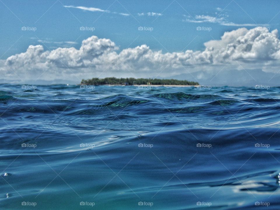 Ocean with small tropical island in the distance
