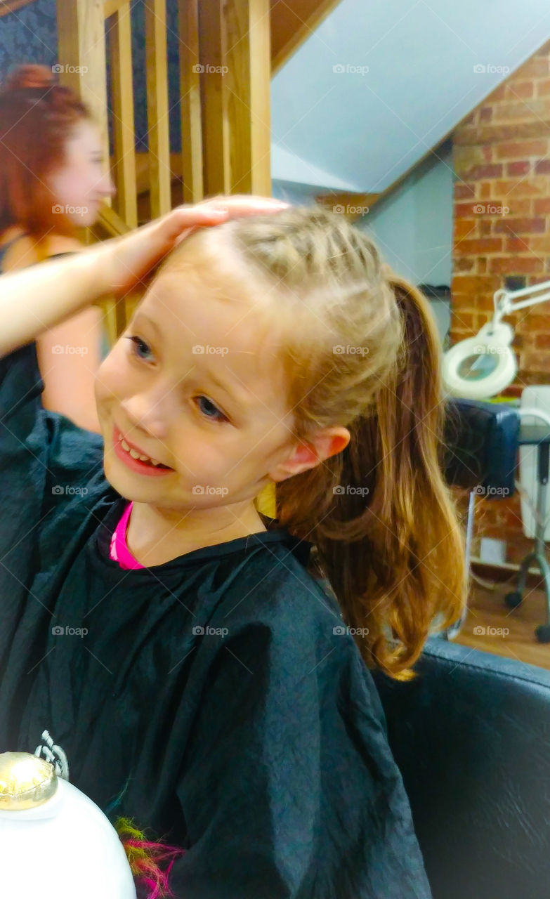 little girl in hairdresser first hair cut