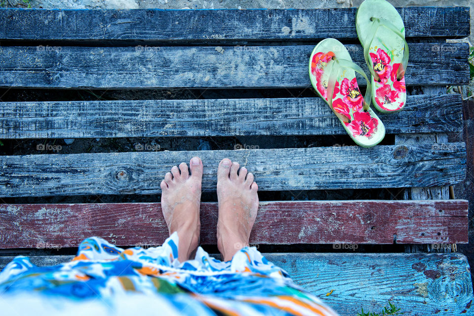 photo of feet and slippers on the wooden background