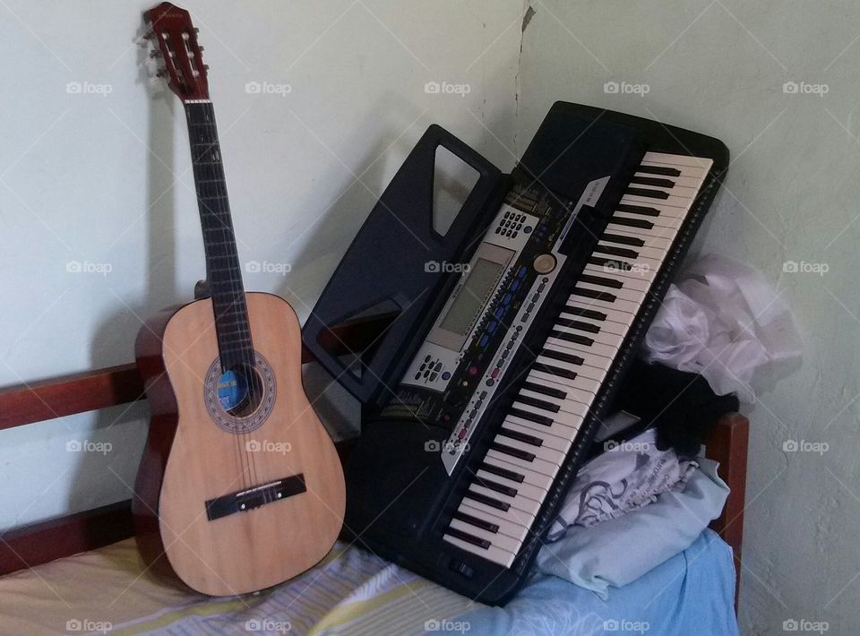 violão e teclado em cima de um sofá.