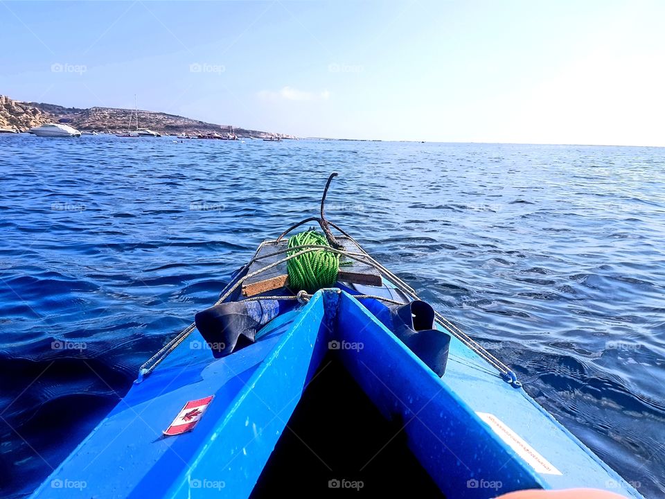 blue kayak gliding on the blue Mediterranean sea under blue skies in Malta