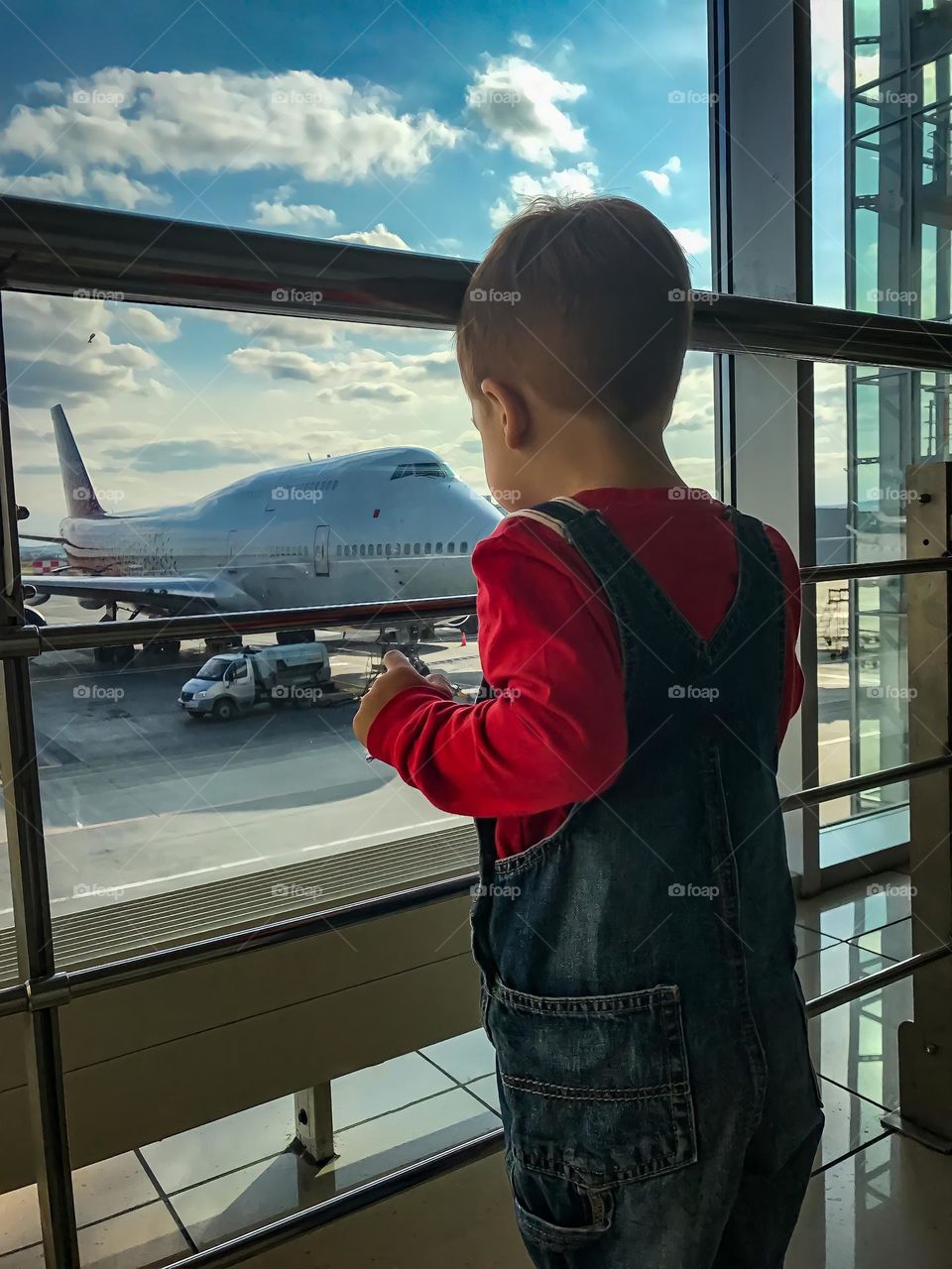 Boy looking at the window in the airport 