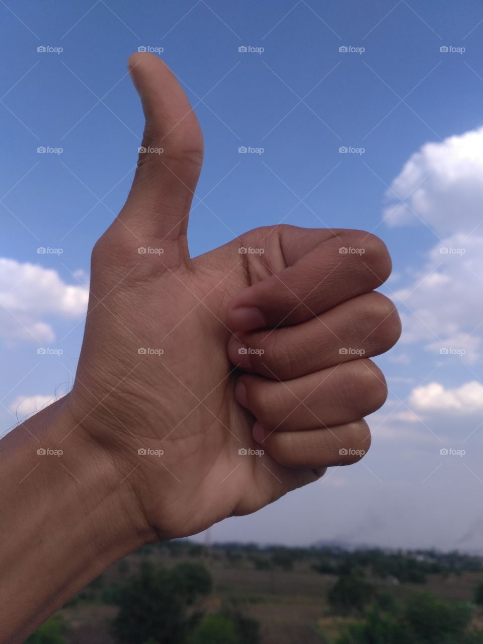 Thumbs Up ! in front of Cloudy sky / it's Ok / gesture / clear sky / palm (hand) / fair weather