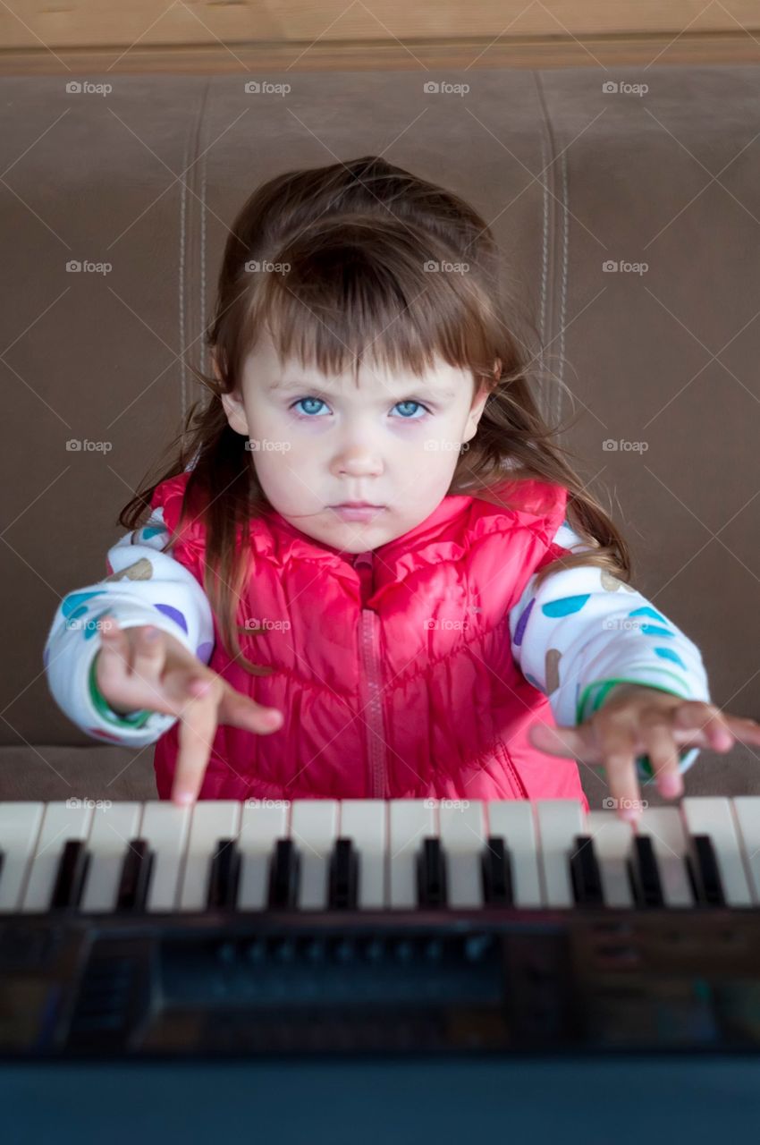 little serious girl playing piano