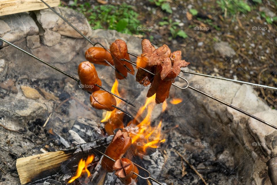 cooking the sausages and meat over the fire