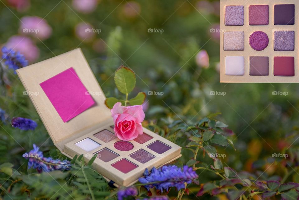 Eye shadow palette on floral background.