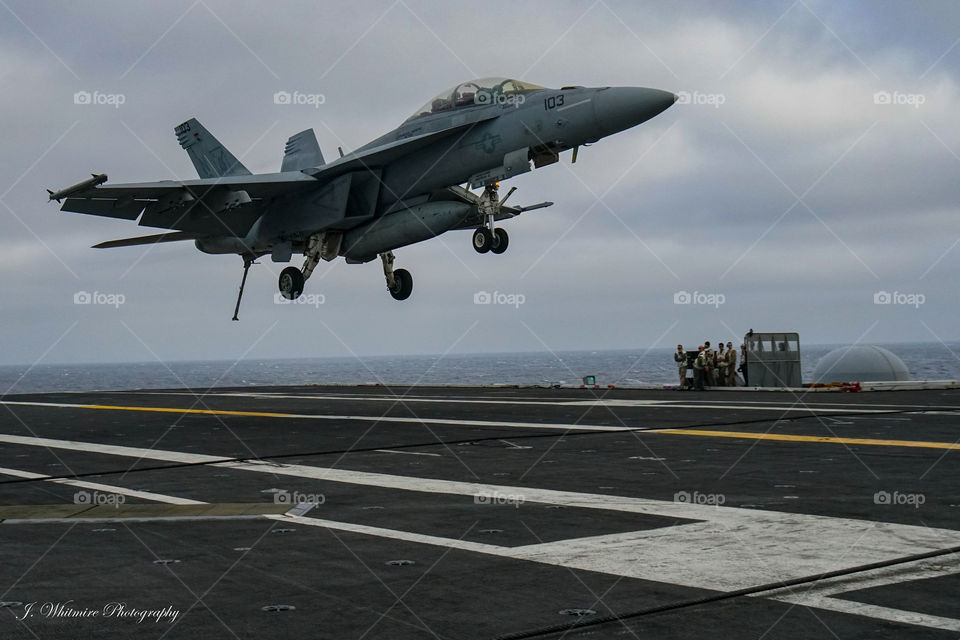 A F/A-18 Super Hornet comes close to touching down on a aircraft carrier deck