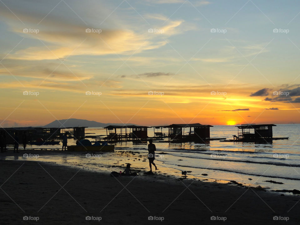 Scenic view of beach against sky at sunset 
