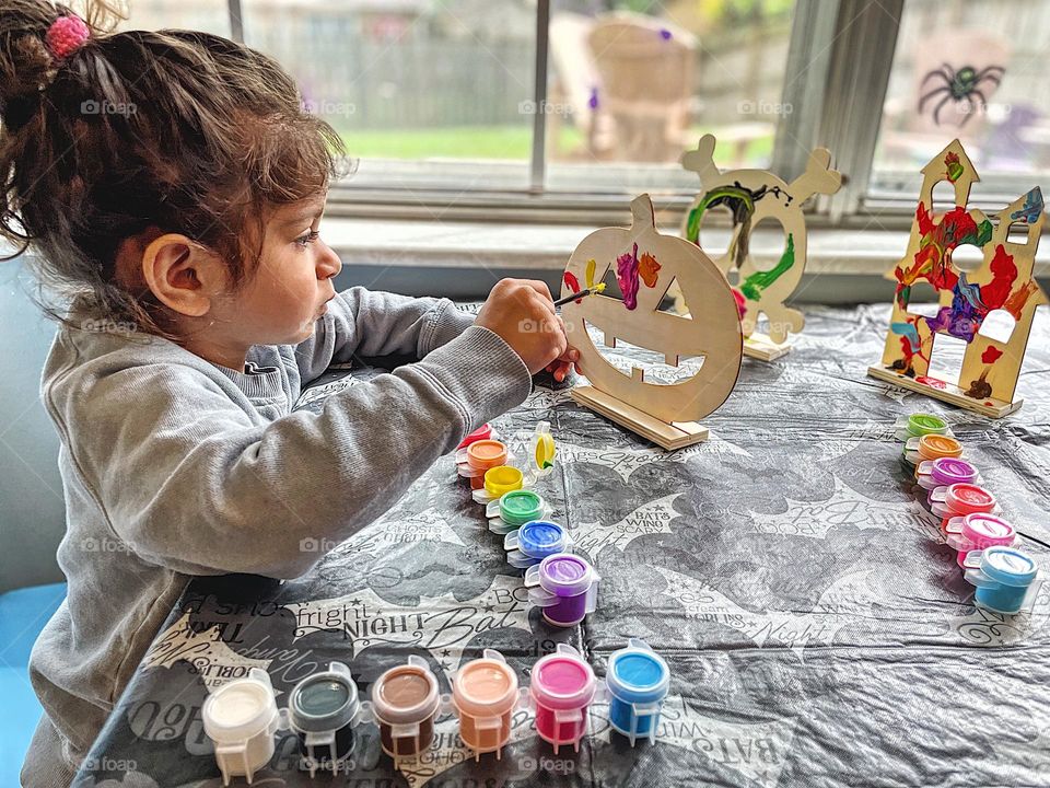 Toddler creates art project, toddler makes art for Grandma, toddler painting, making Halloween decorations, toddler girl makes decorating for Halloween fun, making Halloween decorations