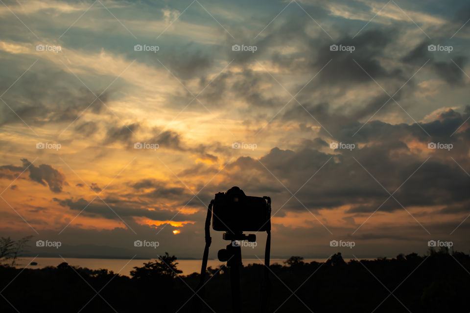 Camera and sunrise over Si Nakharin dam at Huay Mae khamin waterfall National Park ,Kanchana buri in Thailand.