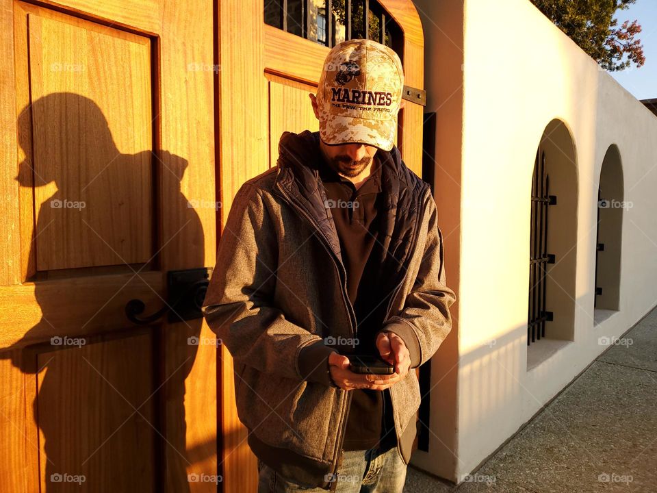 Fall clothing.  A man wearing a polo shirt with jeans and a light jacket at sunset for the cooler fall weather in the evenings.