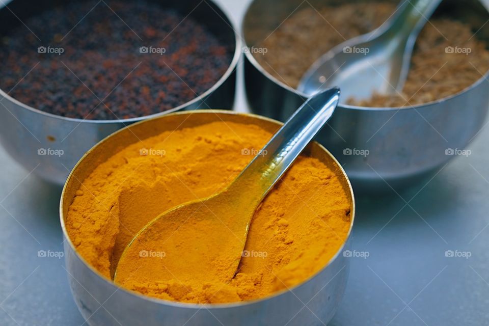 Indian Spices In Metal Containers, Cooking with Indian Spices, Tumeric and Indian Spices, Preparing to cook with Spices, Preparation In the Kitchen, Spices on the countertop ready to Cook, Spices With Spoons