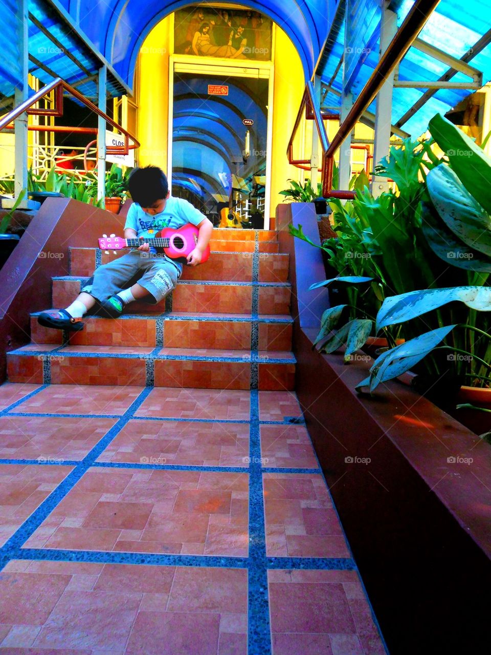 asian child with a yukelele or small guitar